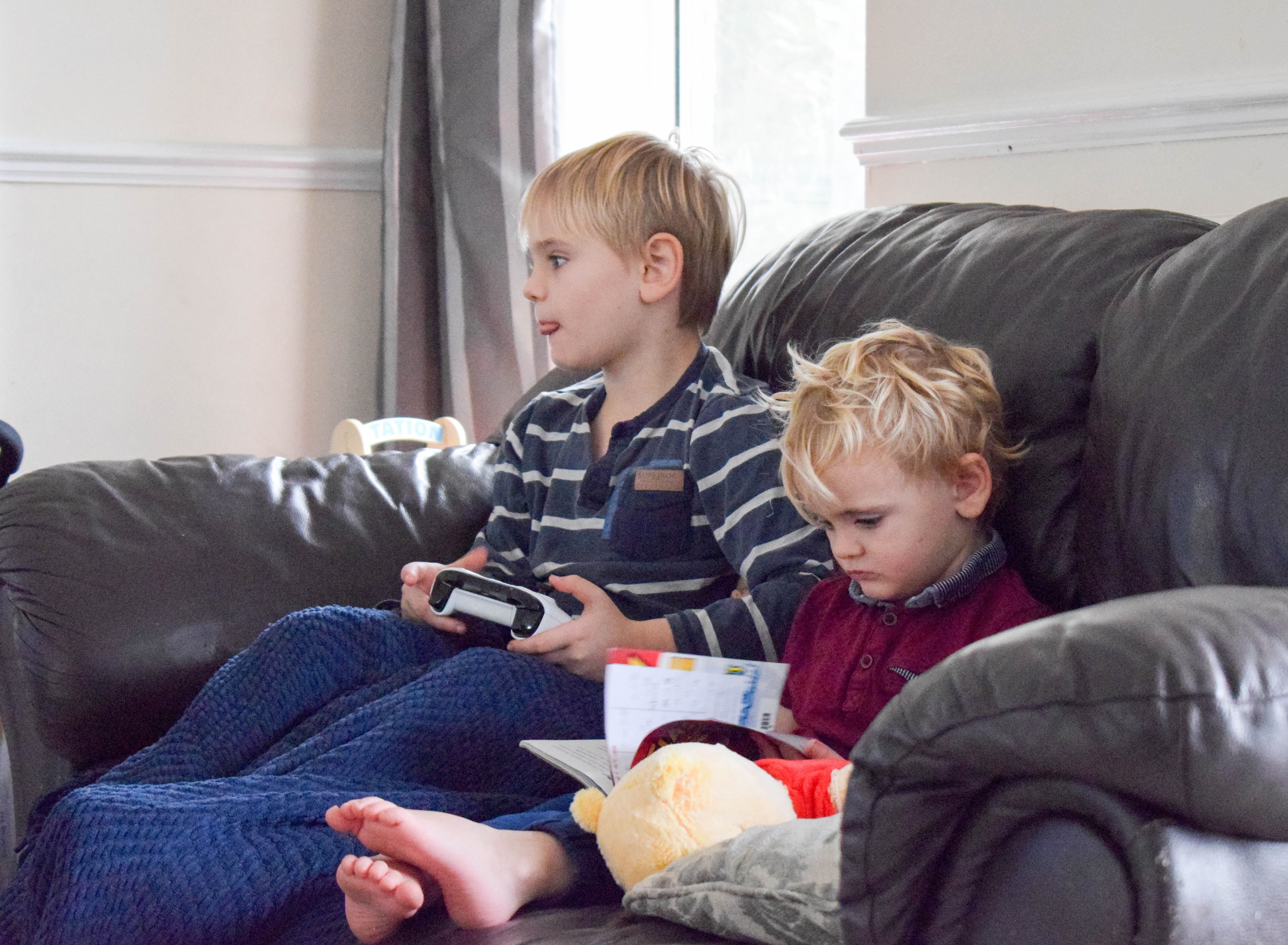 Boy playing xbox and boy reading