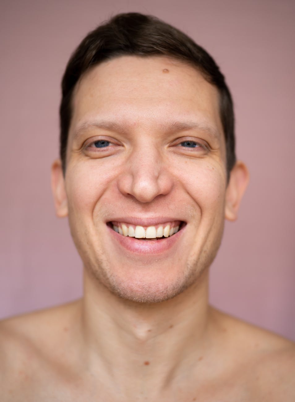 a shirtless man smiling